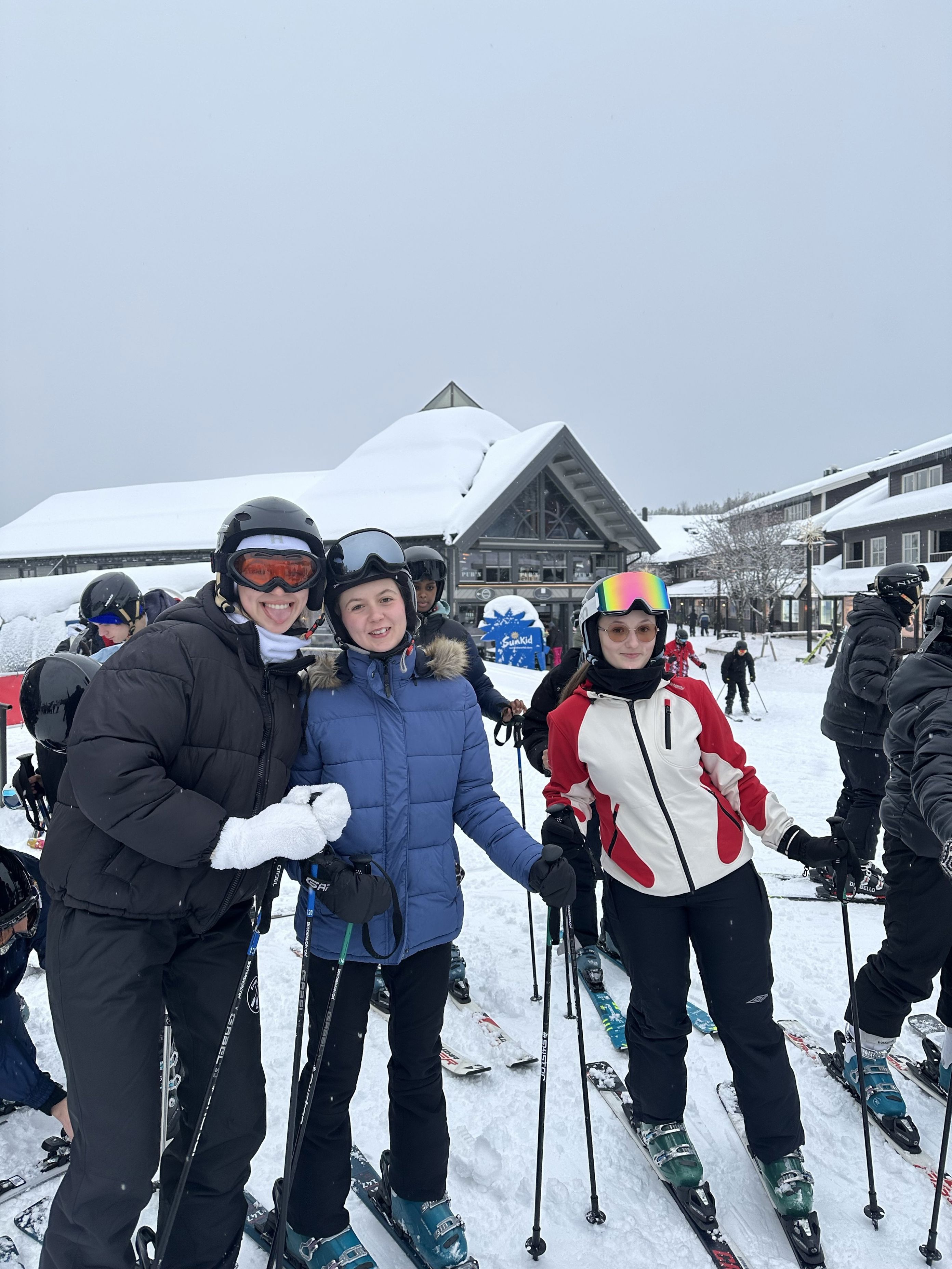 En gruppe mennesker poserer for et bilde på ski En gruppe mennesker poserer for et bilde på ski