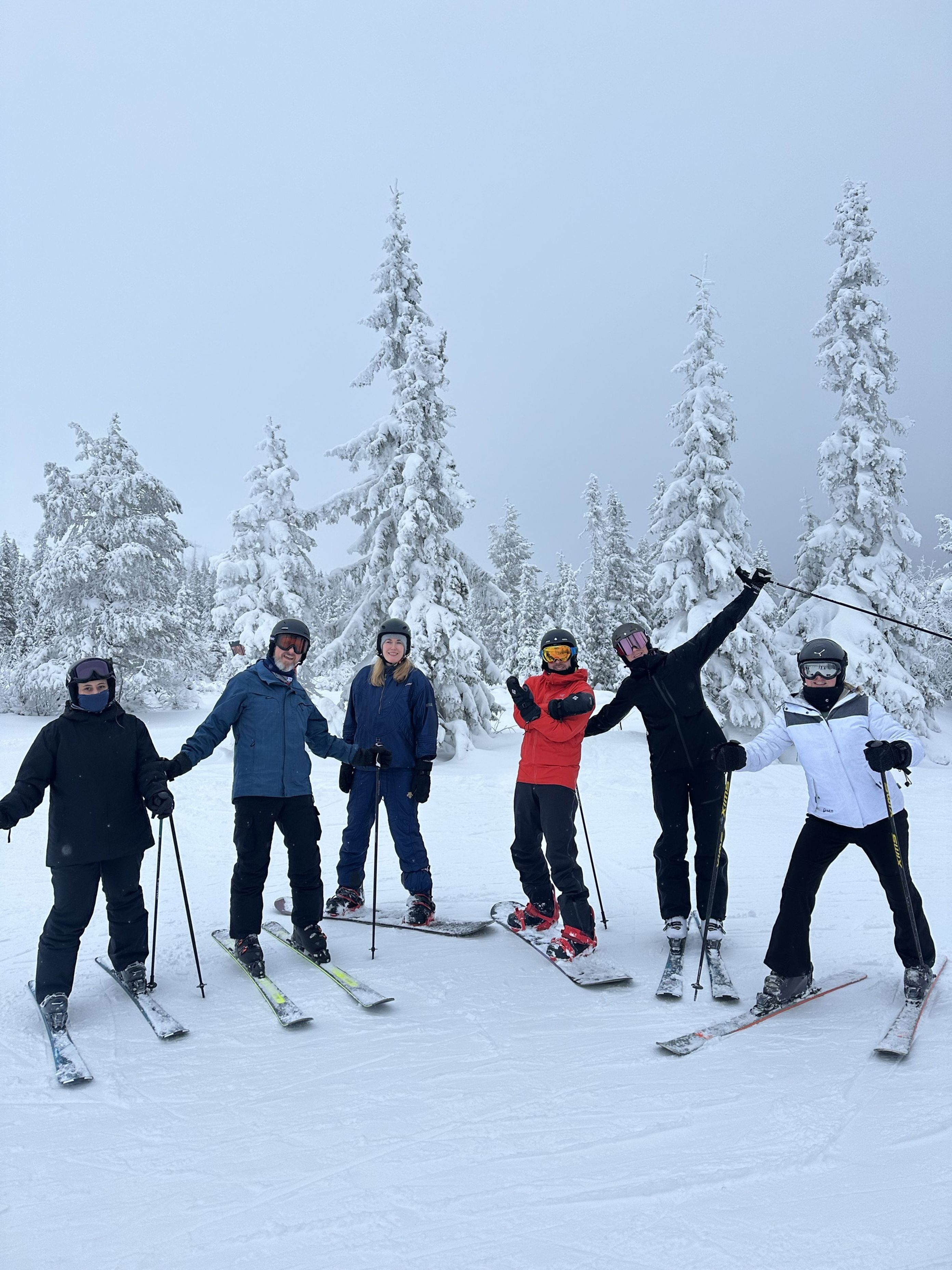 En gruppe mennesker poserer på snøski En gruppe mennesker poserer på snøski
