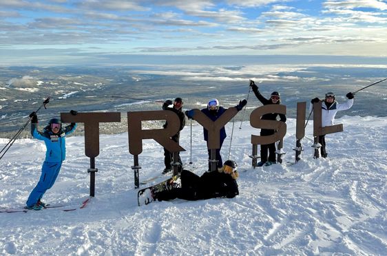 En gruppe mennesker står på snøski