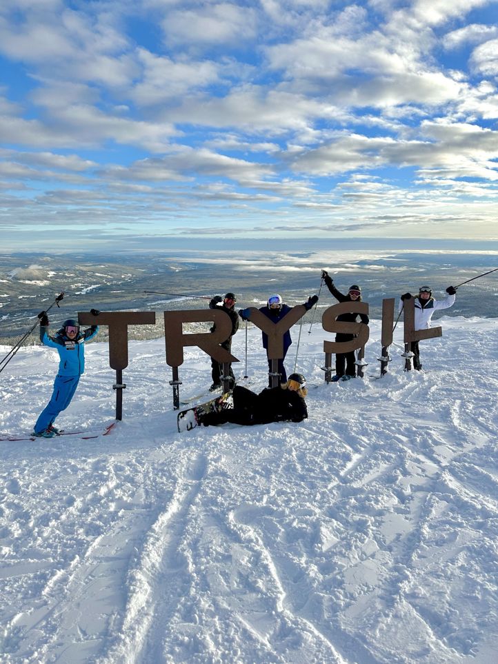 En gruppe mennesker står på snøski