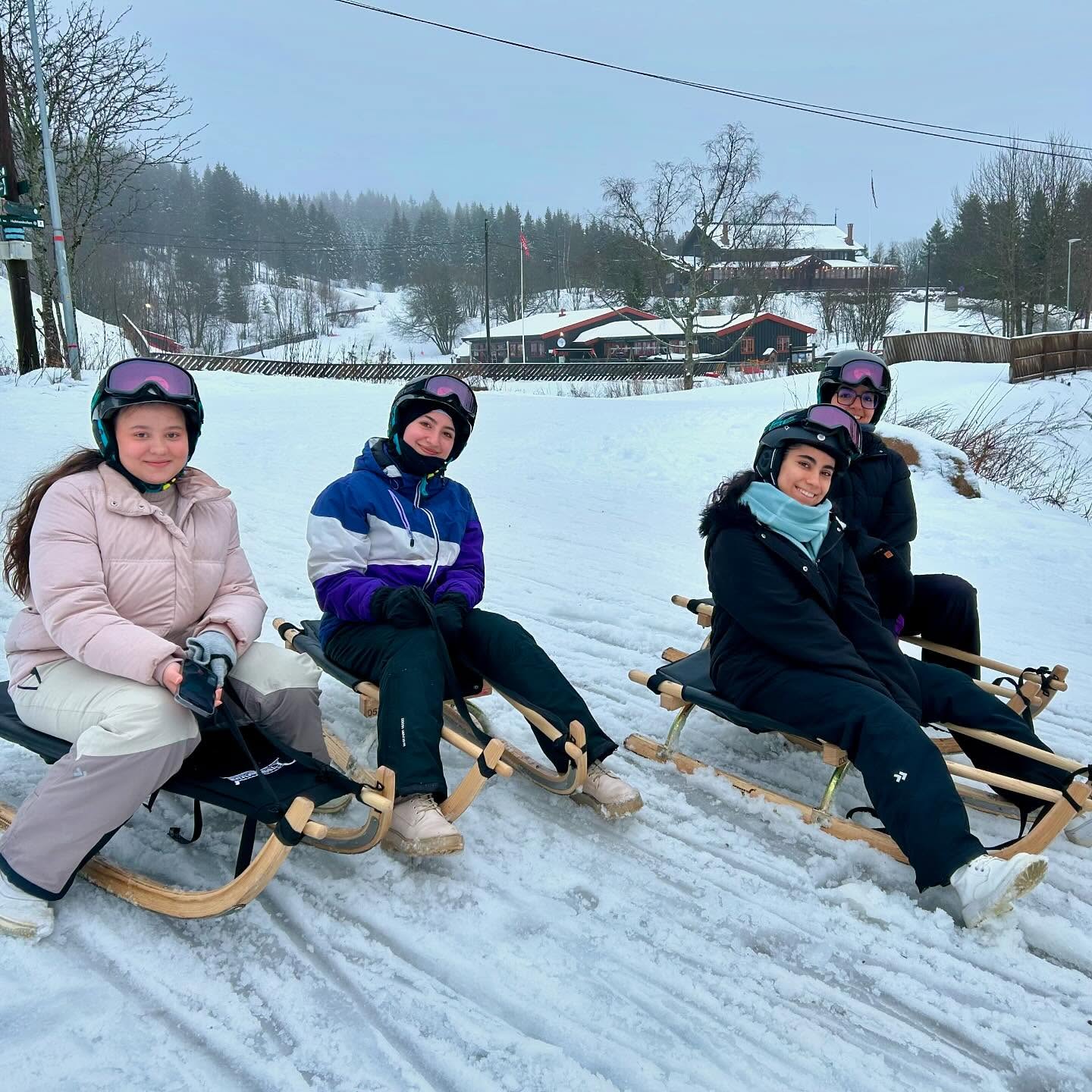 en gruppe mennesker som sitter på en slede i snøen