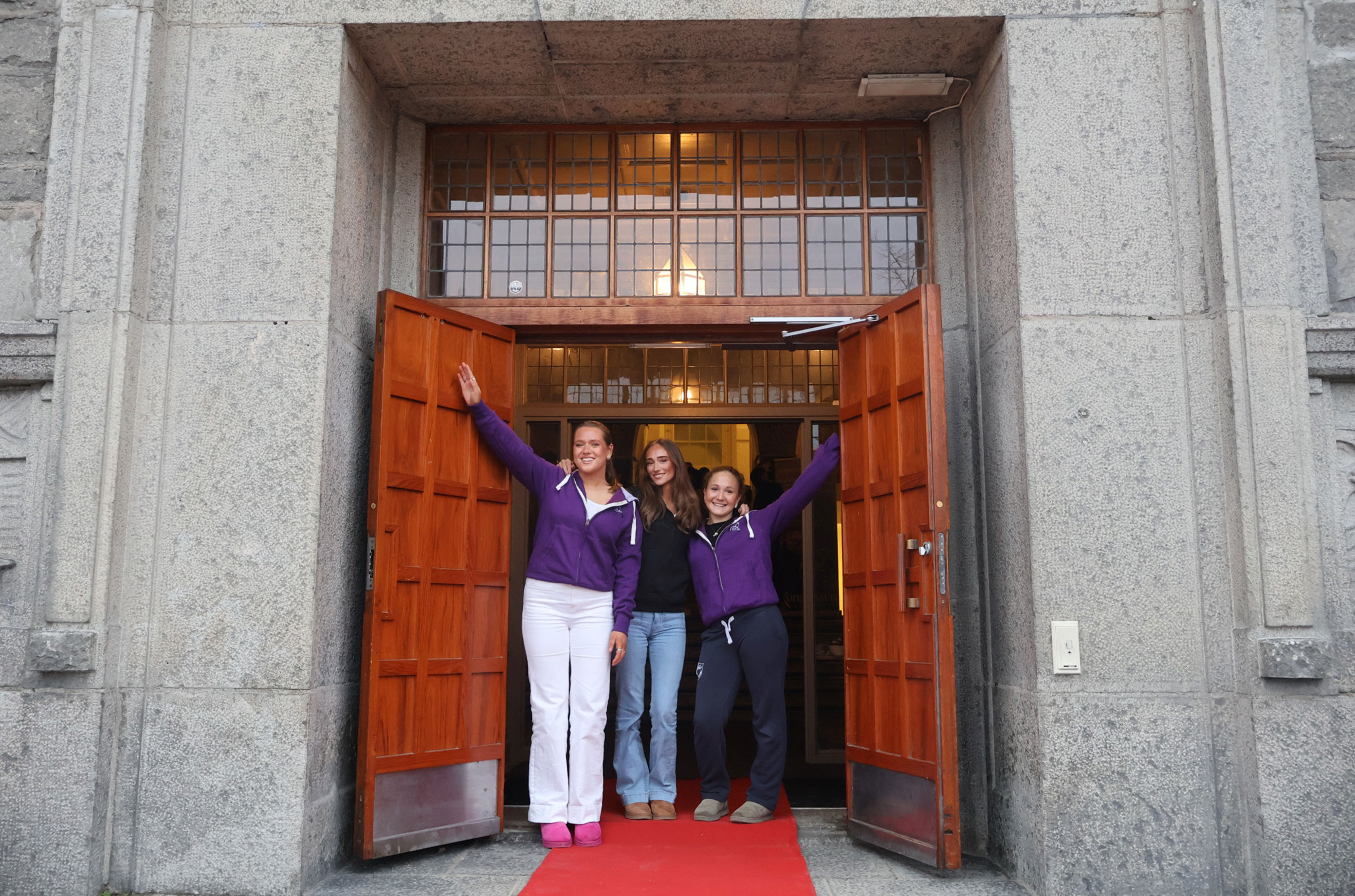 en gruppe personr poserer foran en dør