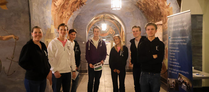 en gruppe mennesker som poserer for et bilde foran en vegg en gruppe mennesker som poserer for et bilde foran en vegg