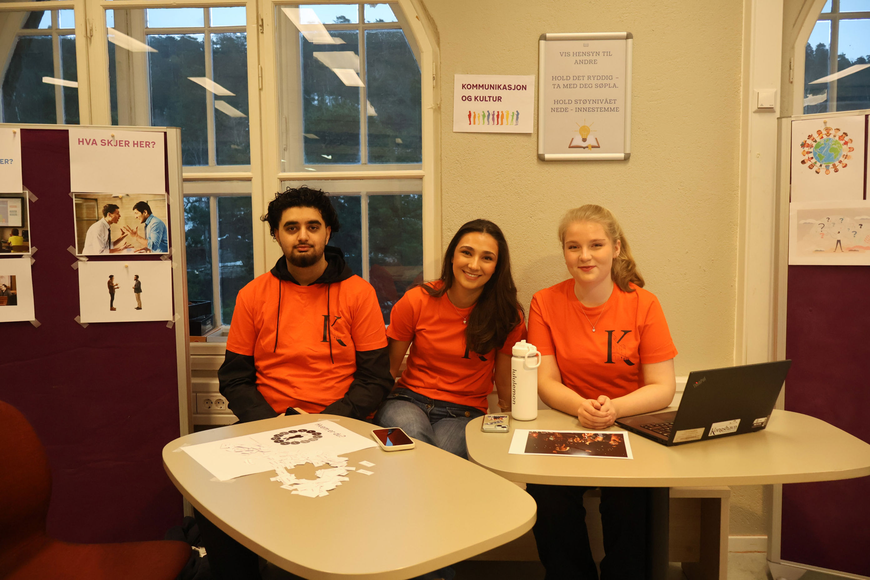 En gruppe mennesker som sitter ved et bord med en bærbar PC