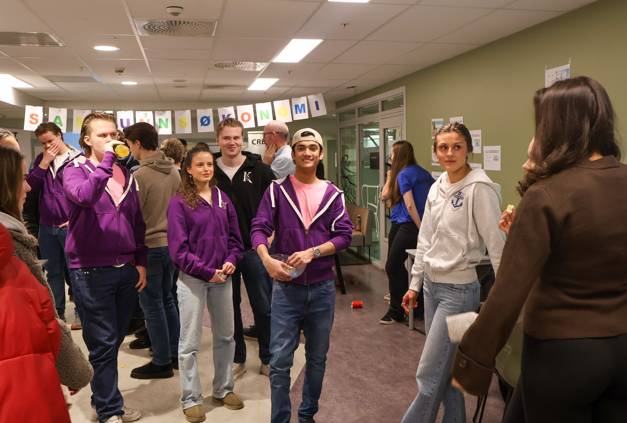 en gruppe mennesker som står i et rom