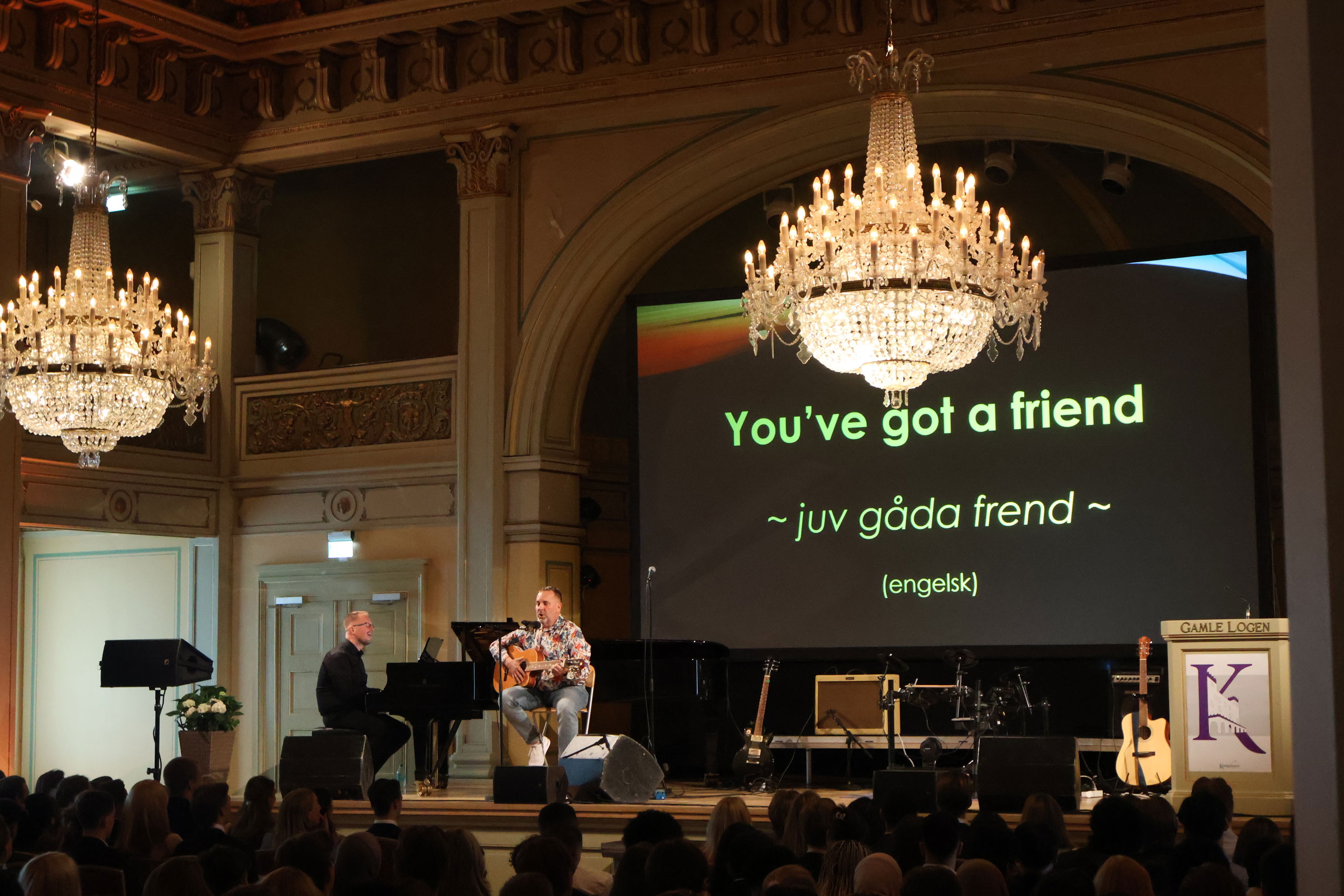 en person som spiller piano på en scene foran et publikum en person som spiller piano på en scene foran et publikum