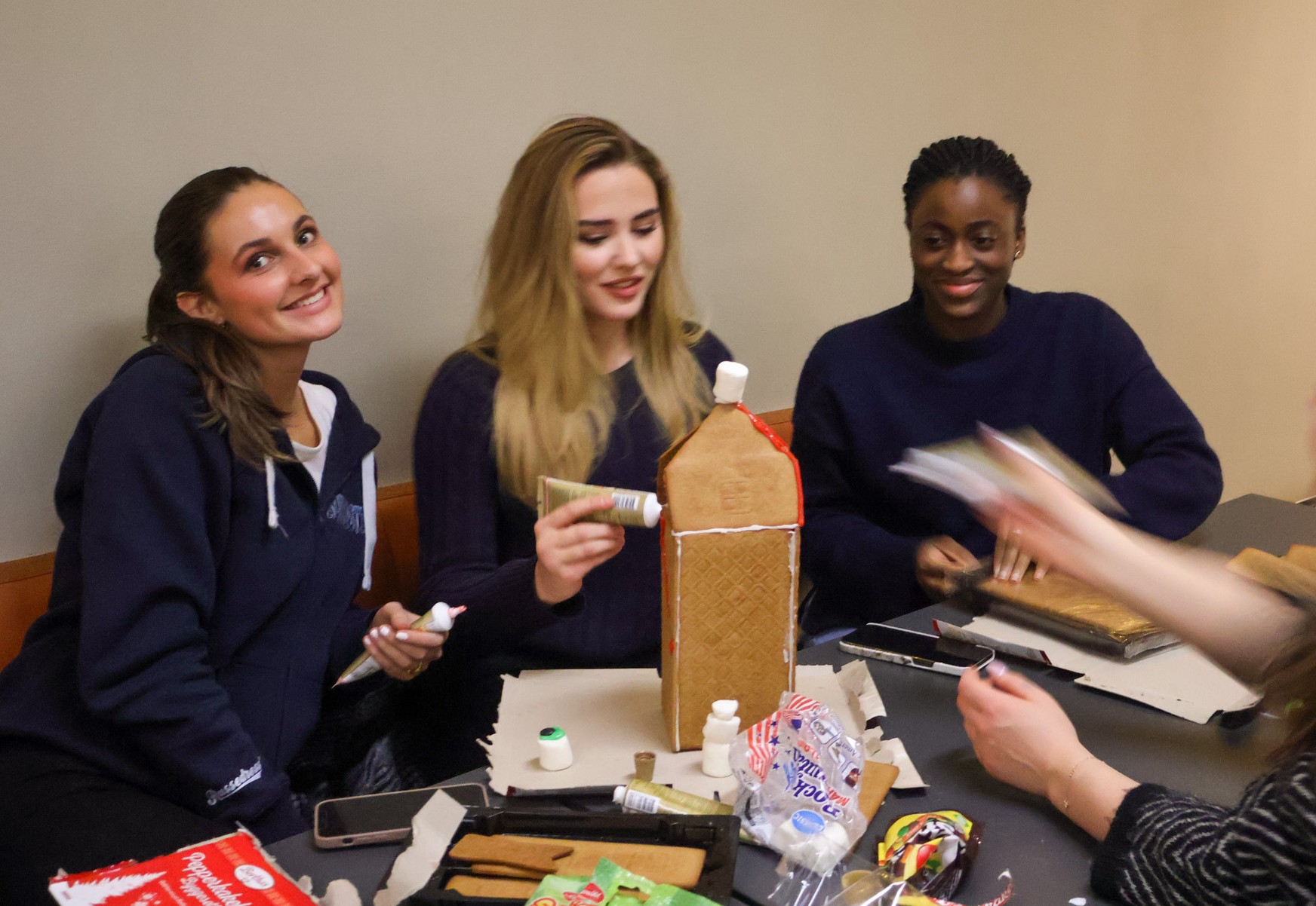 En gruppe mennesker som sitter rundt et bord med mat og drikke