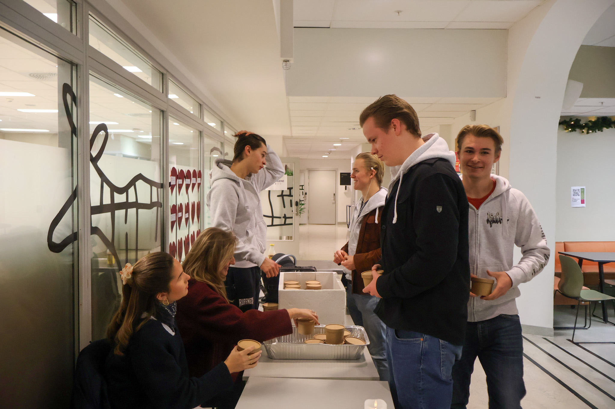 en gruppe mennesker som står rundt et bord med mat på