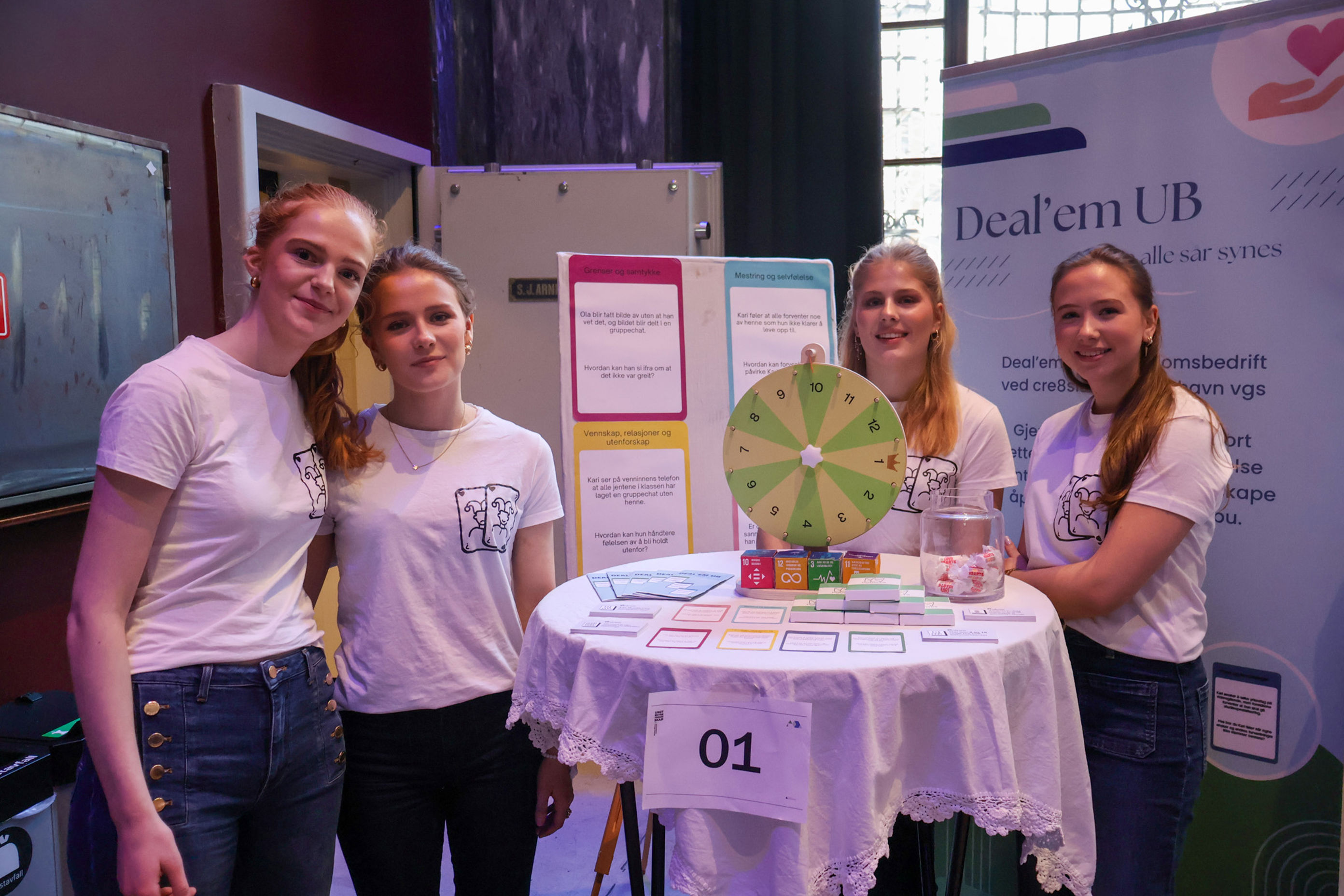 En gruppe personr står ved siden av et bord med et skilt En gruppe personr står ved siden av et bord med et skilt