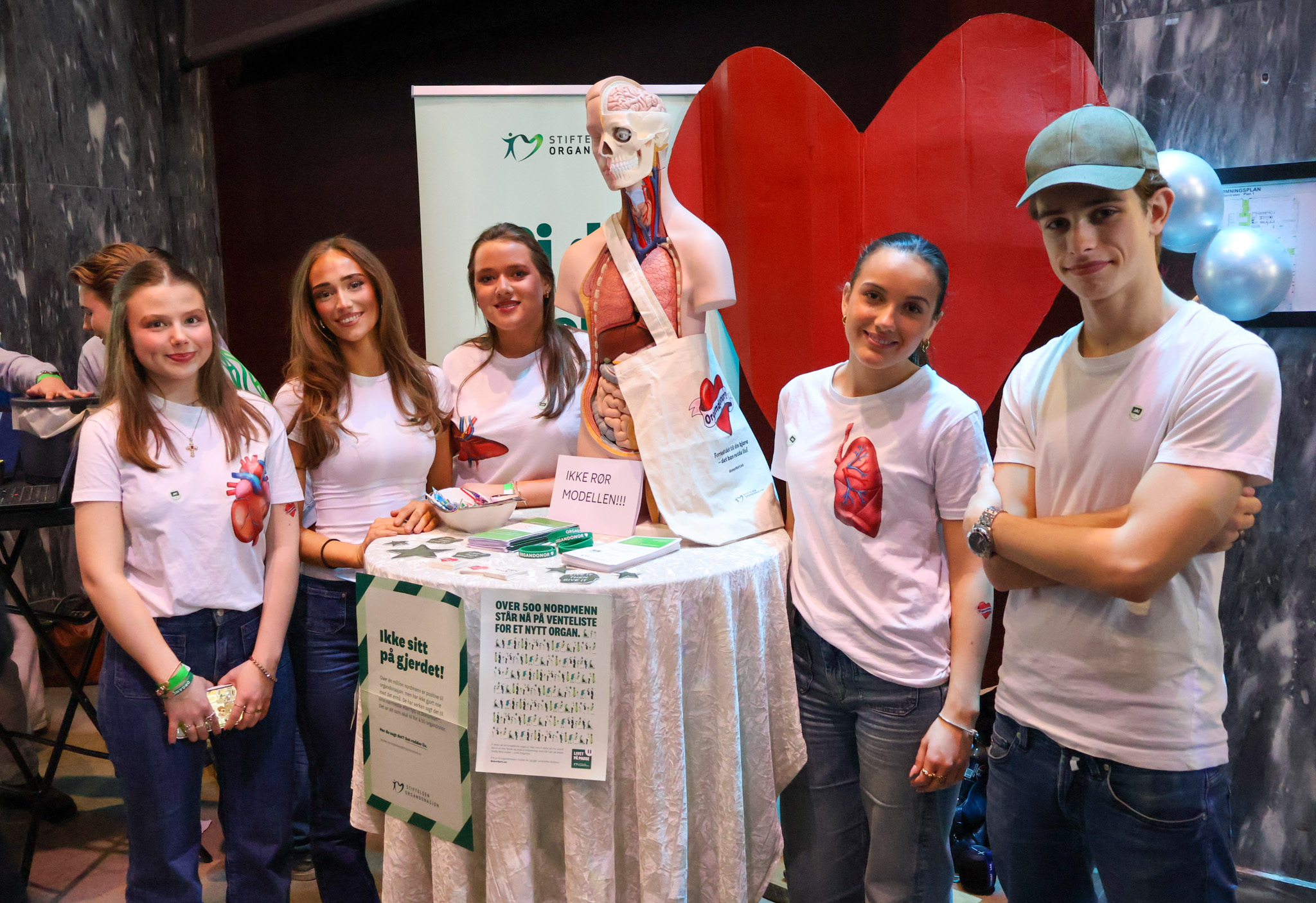 en gruppe mennesker som poserer for et bilde med et skjelett