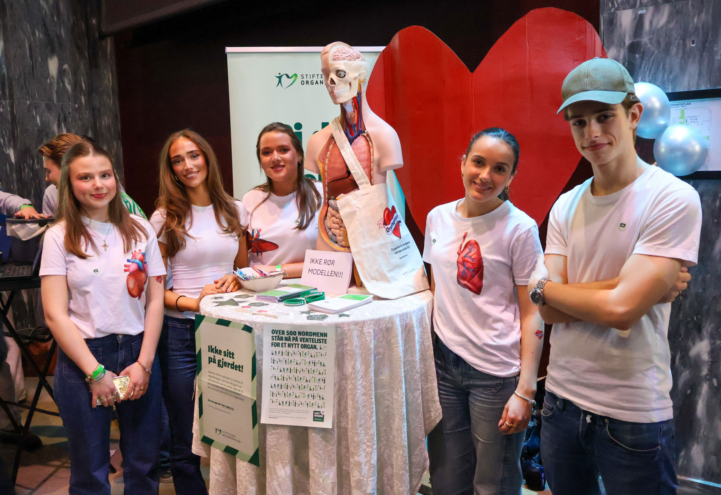 en gruppe mennesker som poserer for et bilde med et skjelett