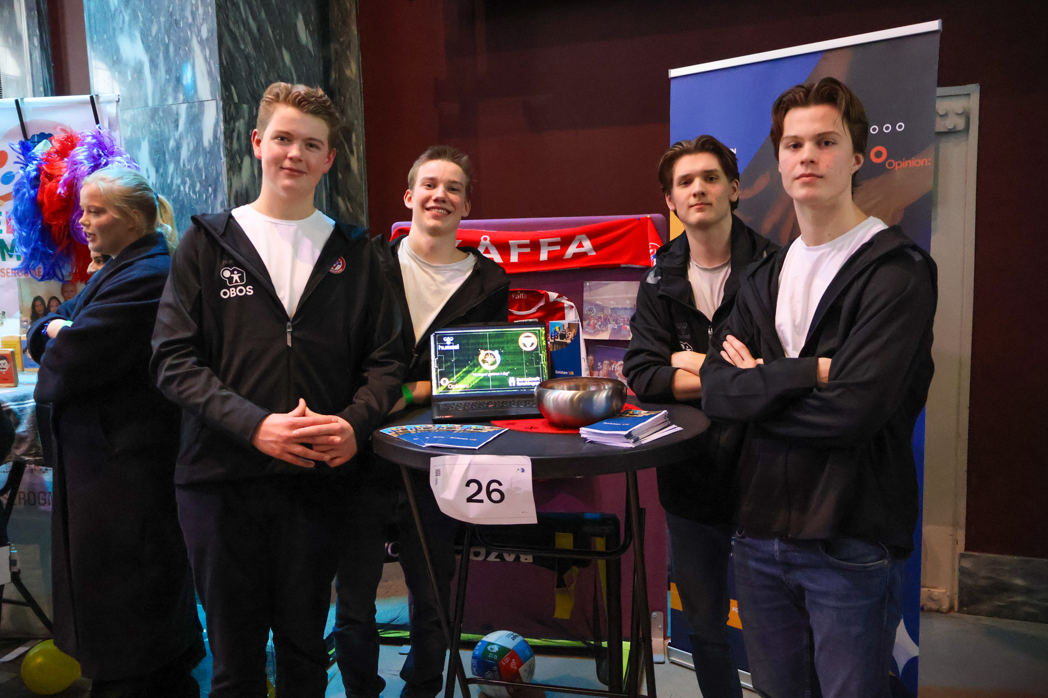 en gruppe mennesker som står rundt et bord med en bærbar PC