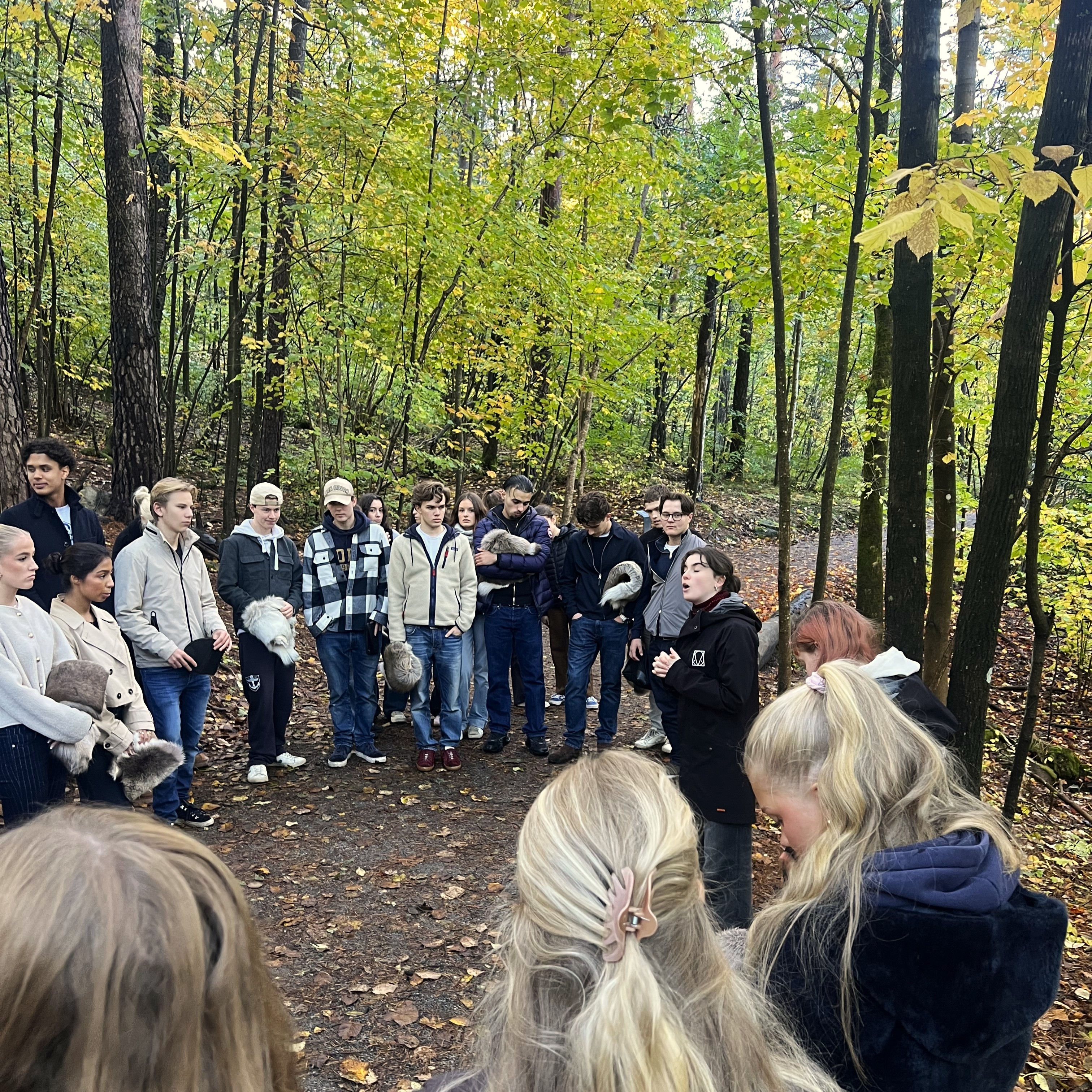 En gruppe mennesker som står i en skog