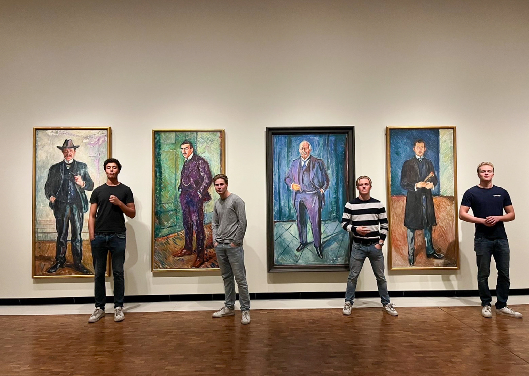 en gruppe menn som står foran en vegg med malerier