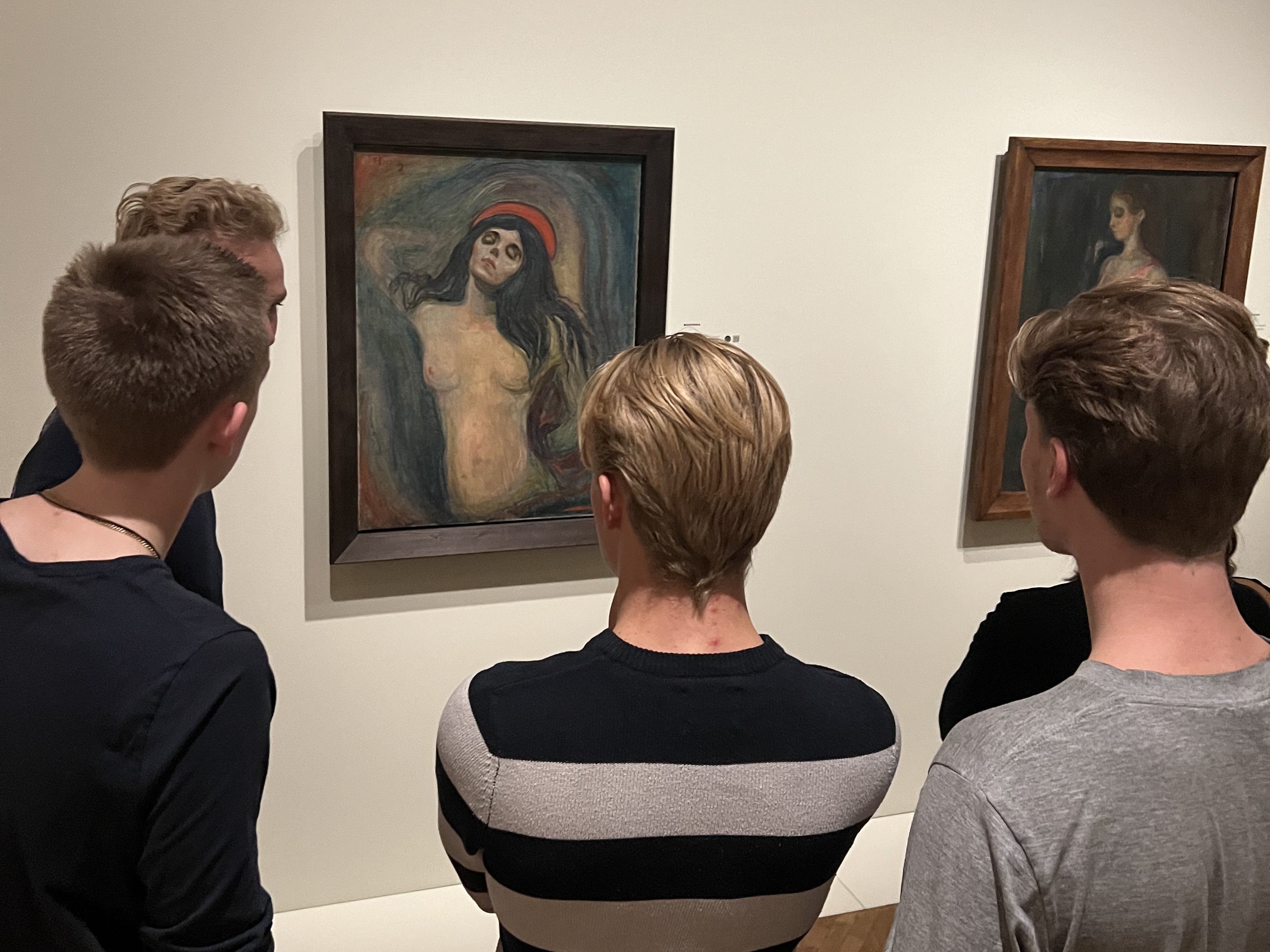 En gruppe mennesker som ser på kunst på en vegg