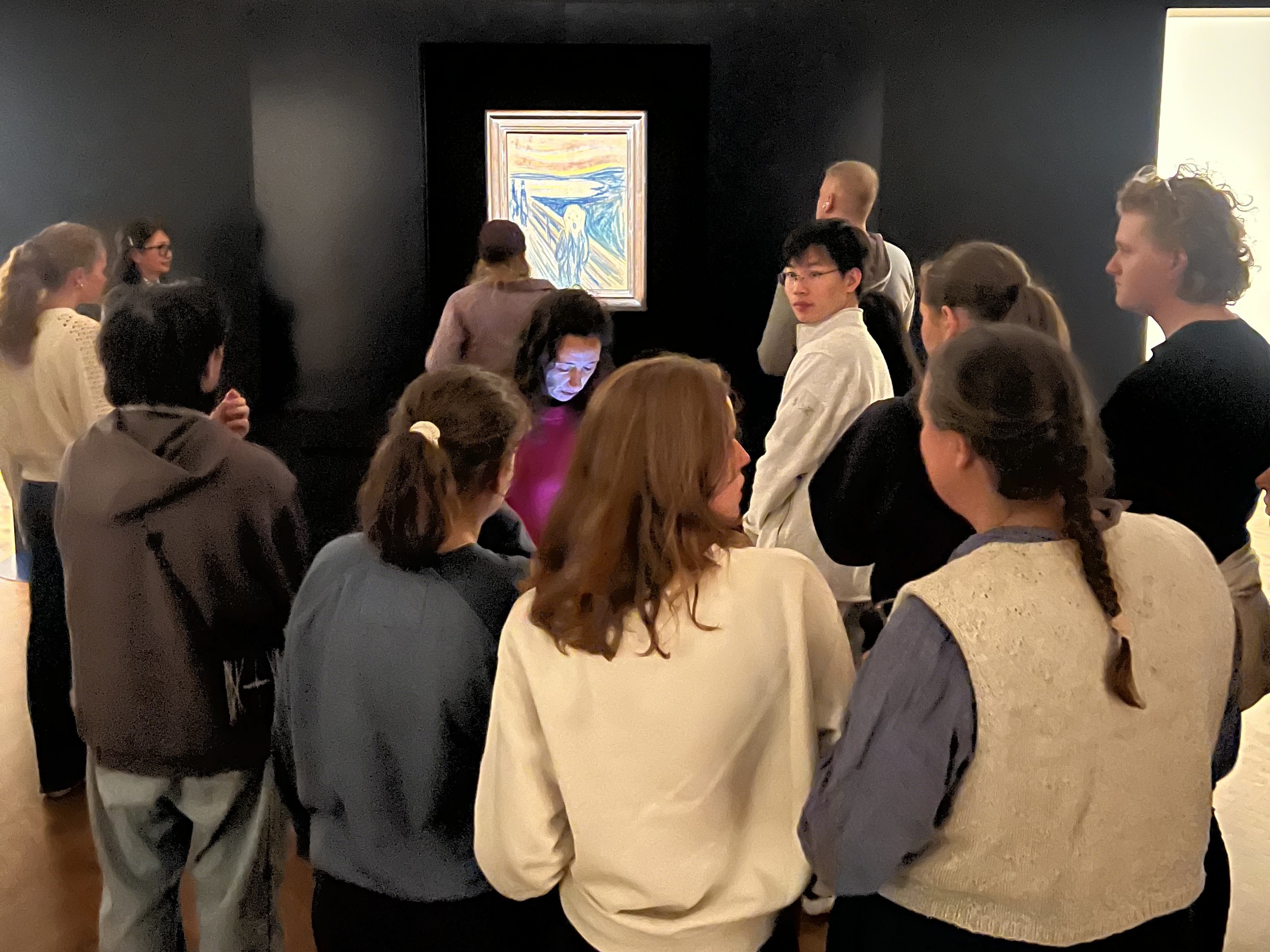 En gruppe mennesker som ser på et maleri på en vegg