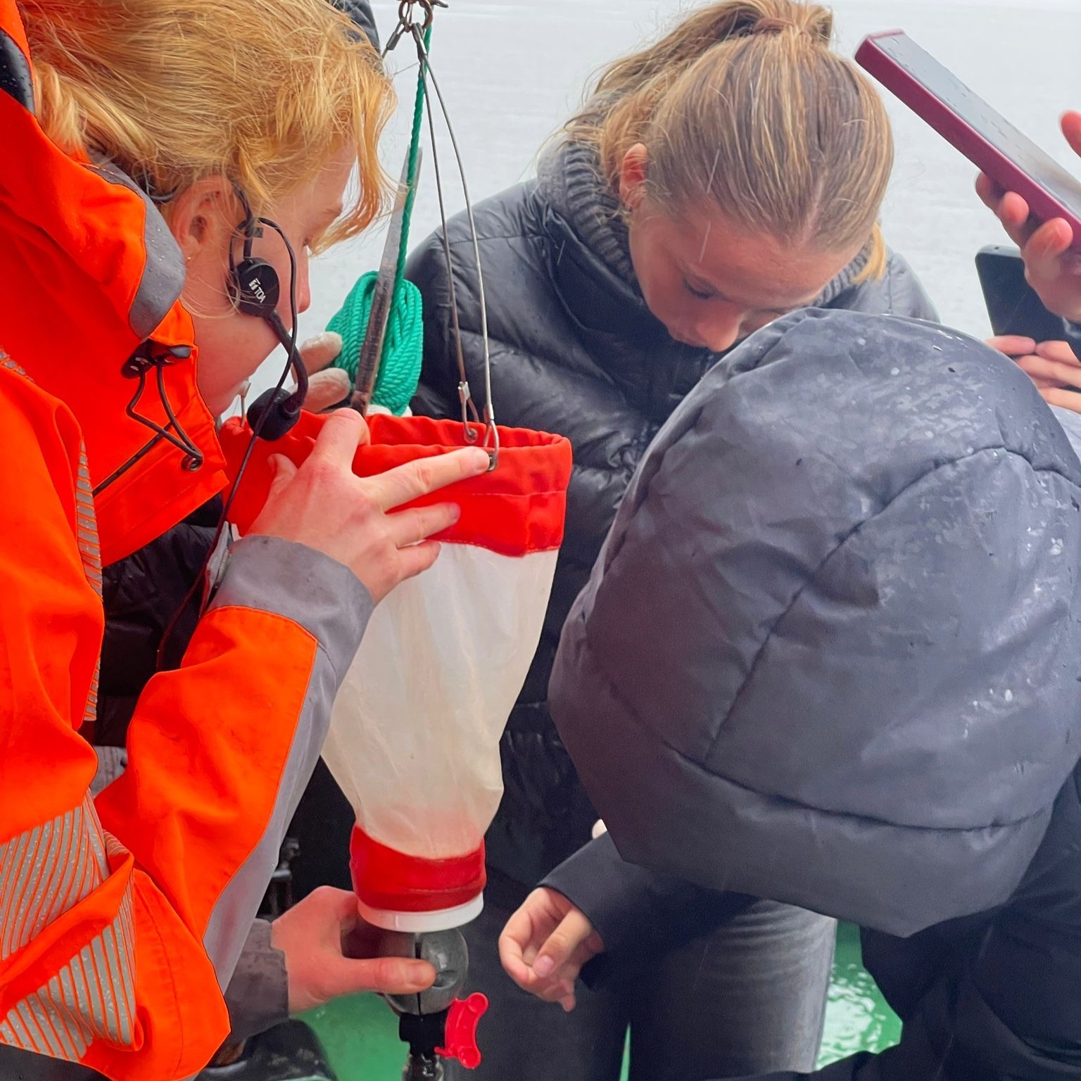 en person som hjelper et barn med en rød gjenstand