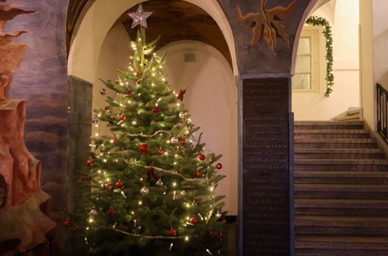 Et pyntet juletre i en steinbygning