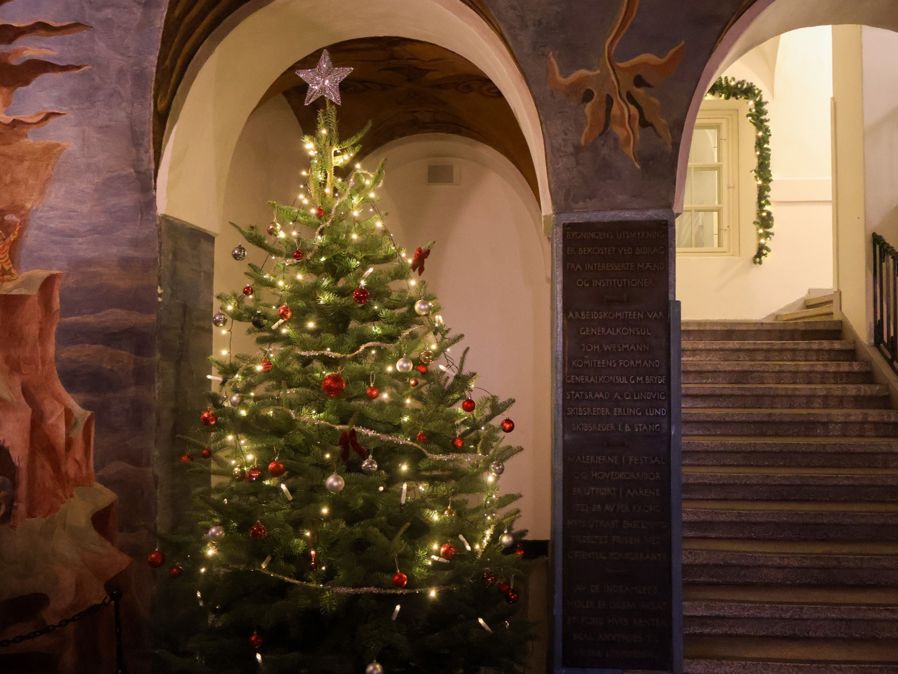 Et pyntet juletre i en steinbygning