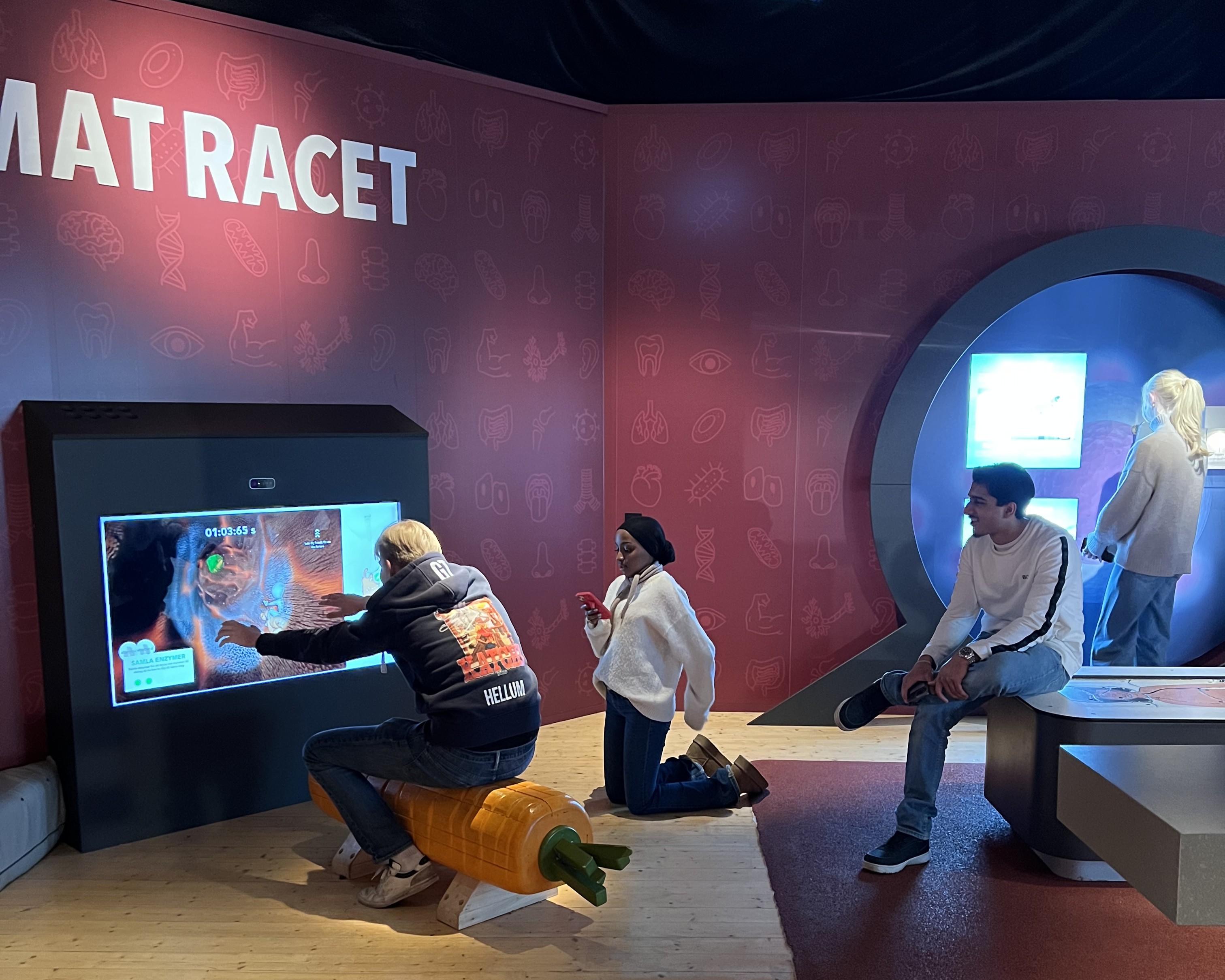 En gruppe mennesker som sitter på en benk foran en TV