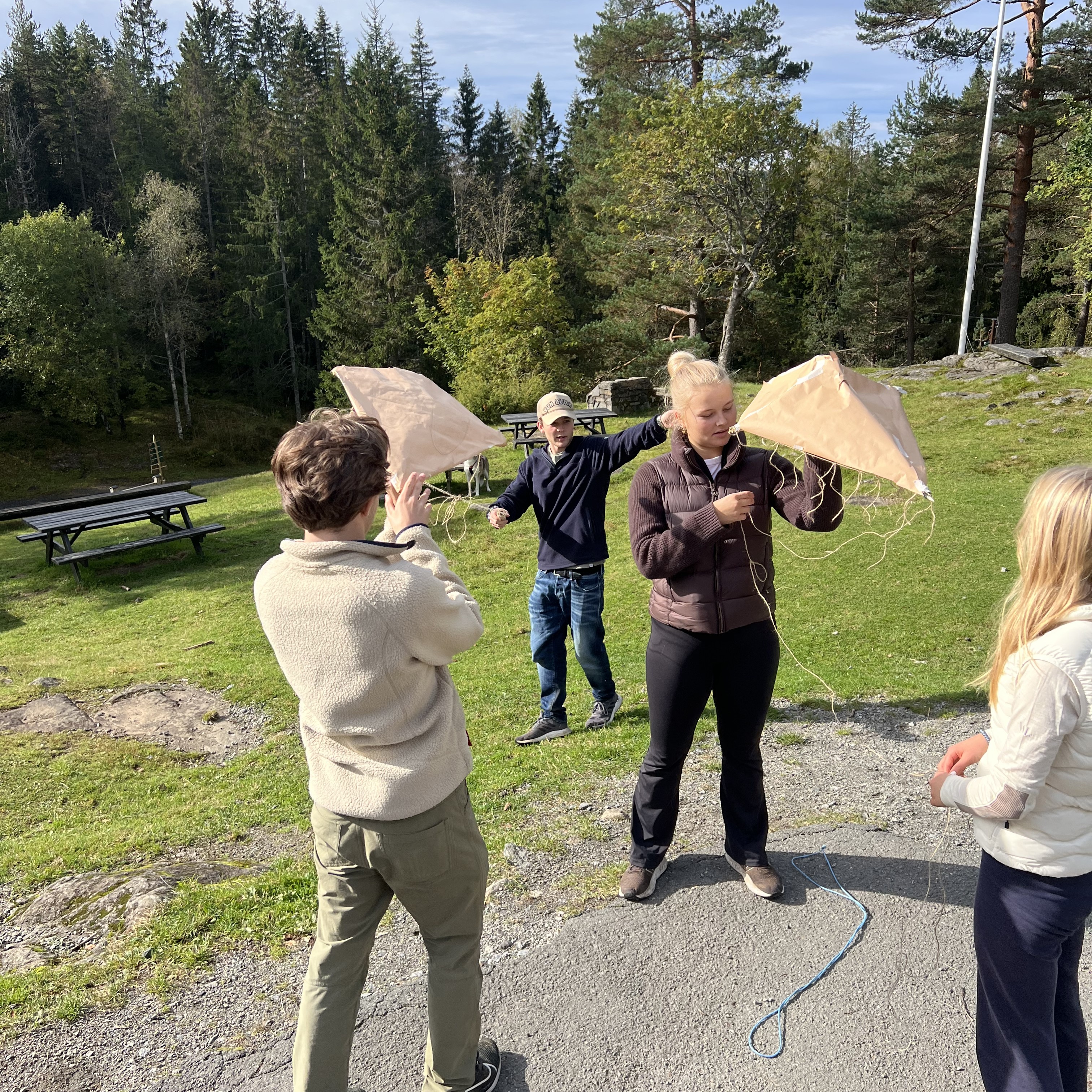 en gruppe mennesker som går på en grussti med en person som holder en paraply