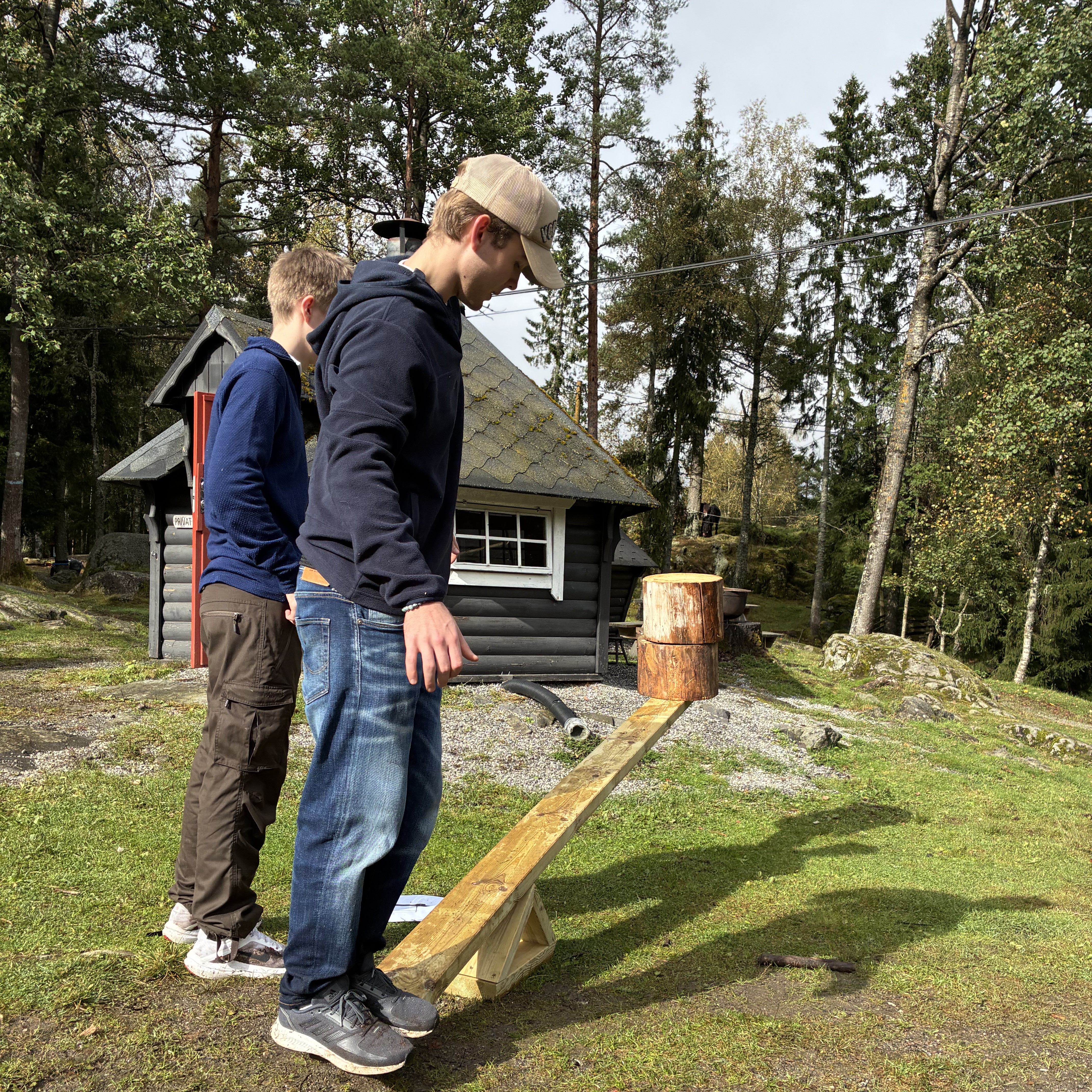 et par menn som står på en plen med et hus i bakgrunnen
