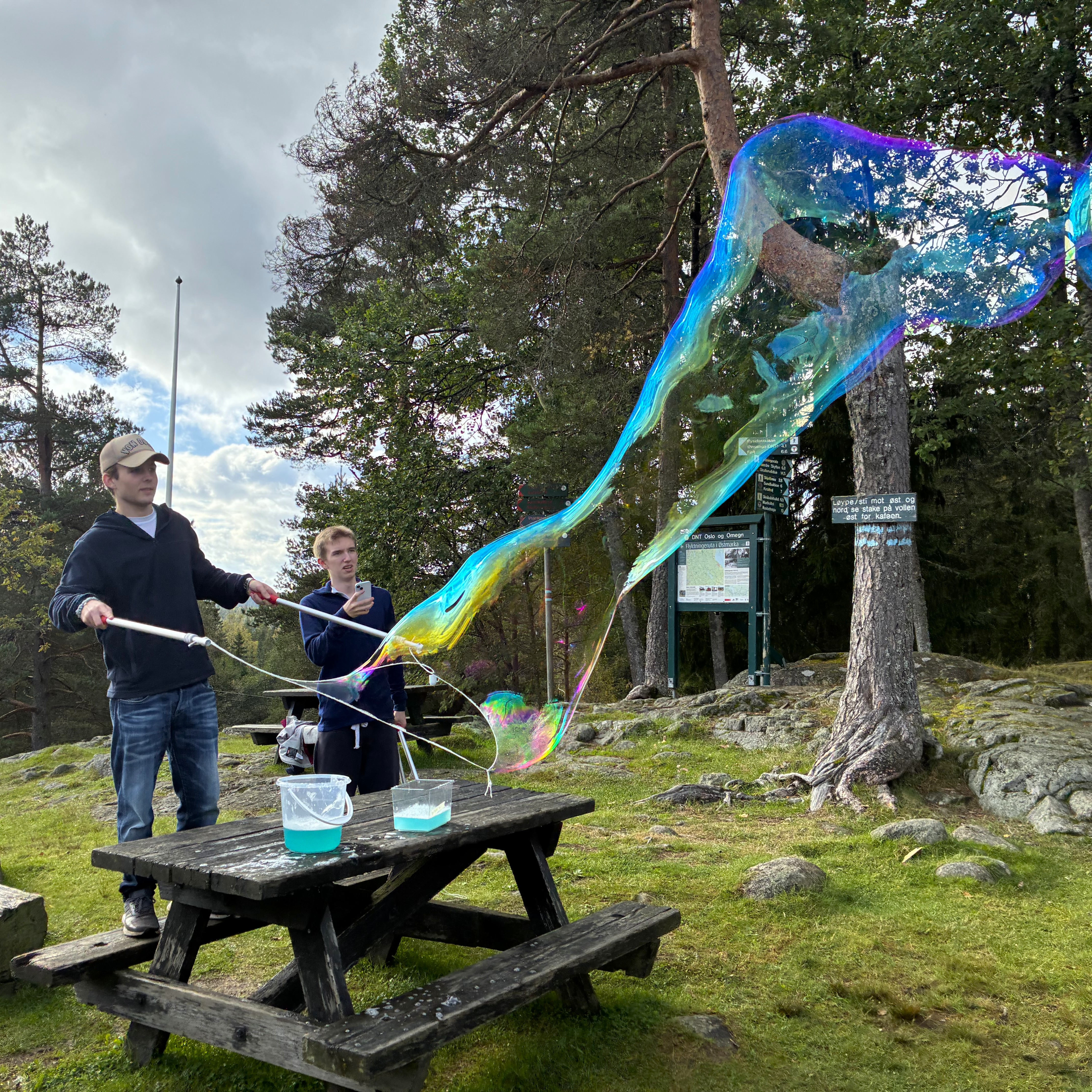 en person og en person som holder en stor blå og grønn gjenstand