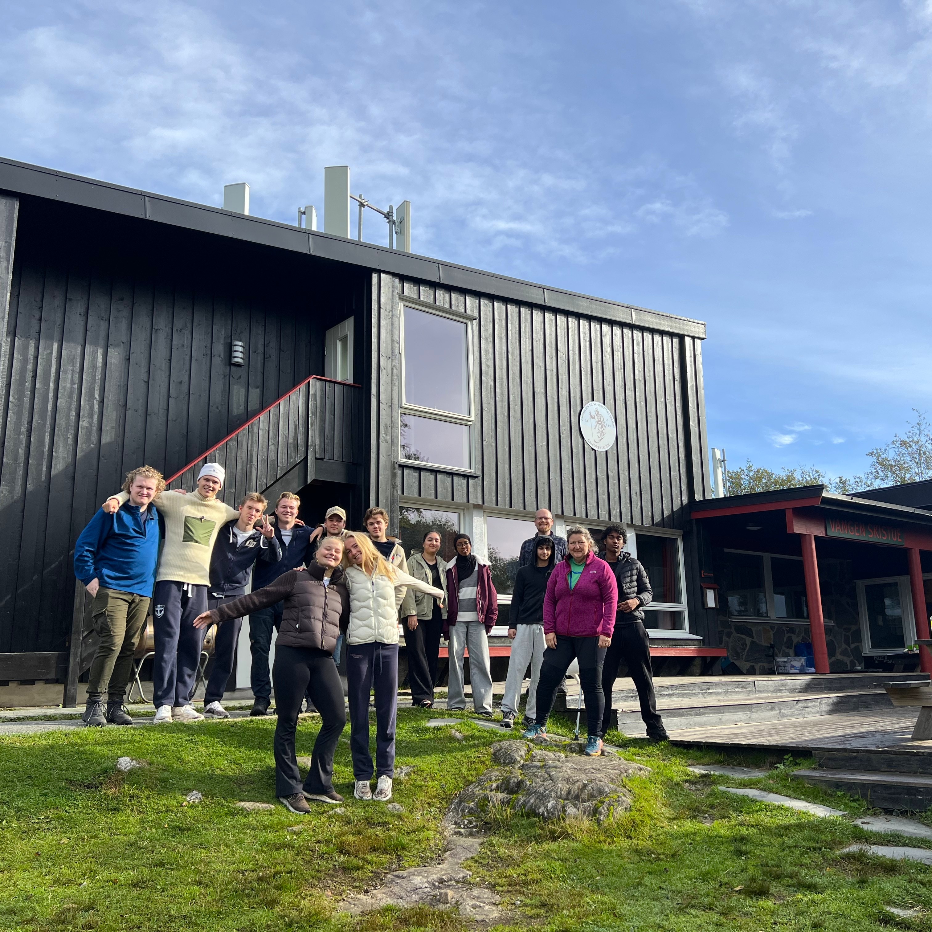 en gruppe mennesker som står utenfor en bygning