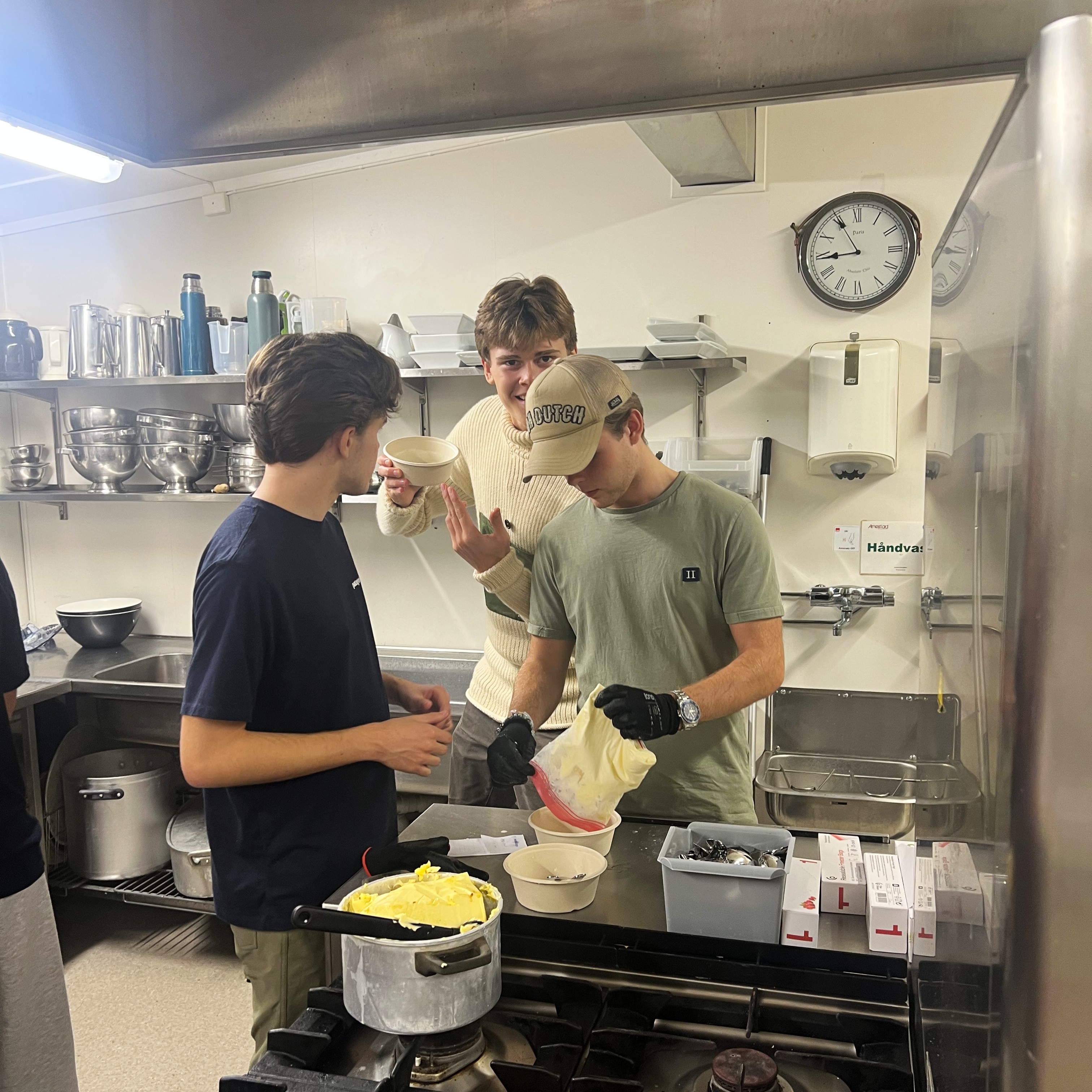 En gruppe mennesker som lager mat på et kjøkken