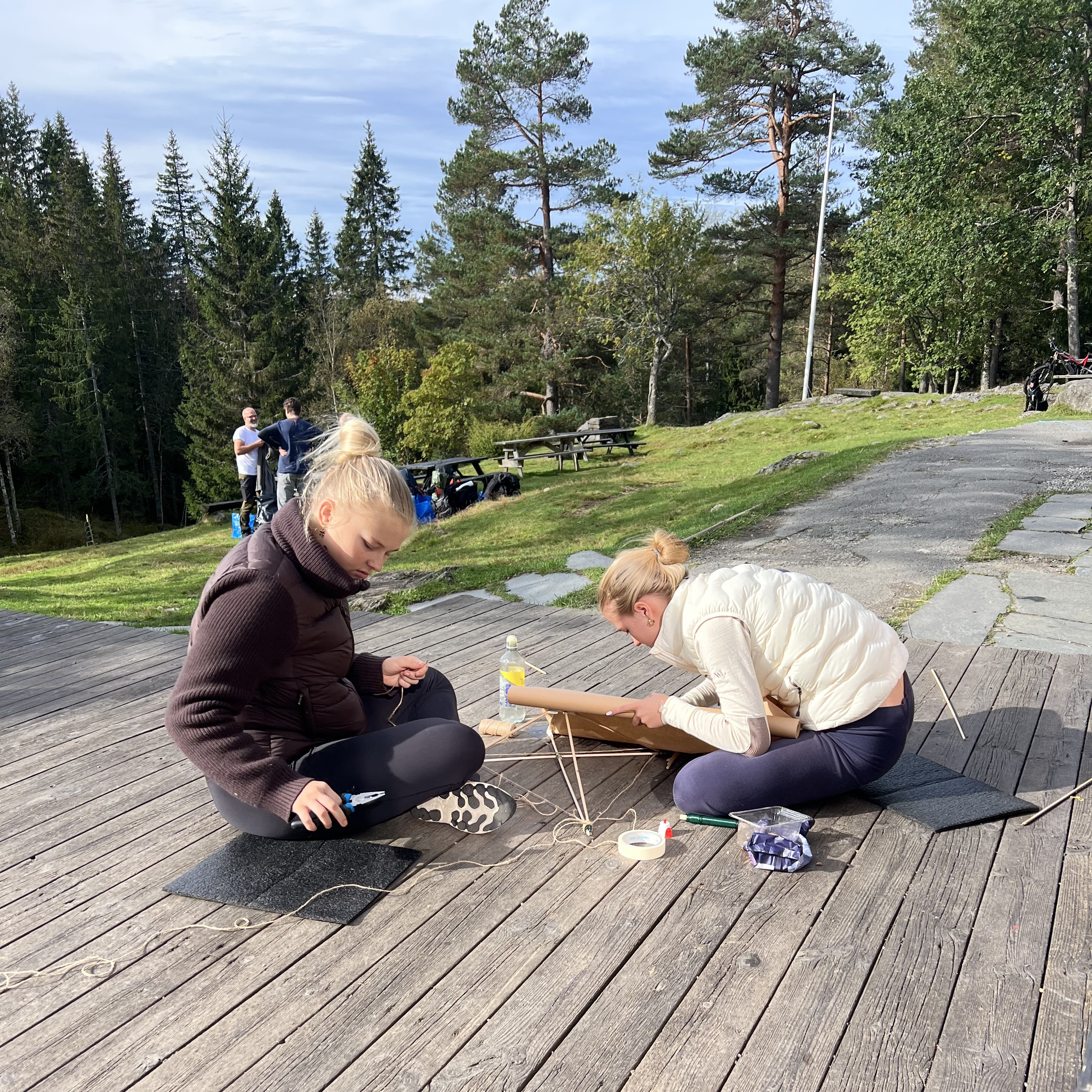 et par personr som sitter på en steingang med trær og gress