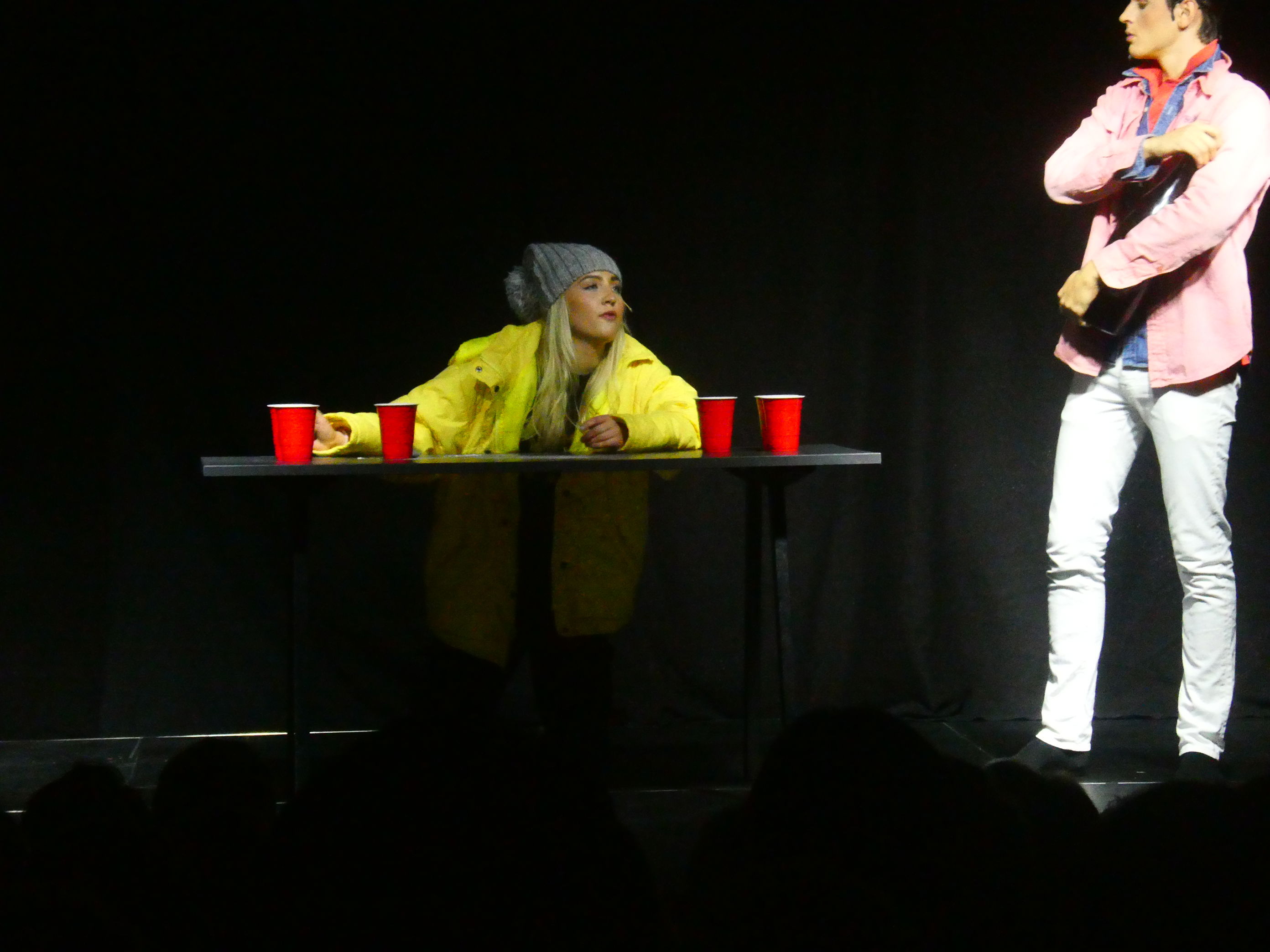 en person som sitter ved et bord med røde kopper på