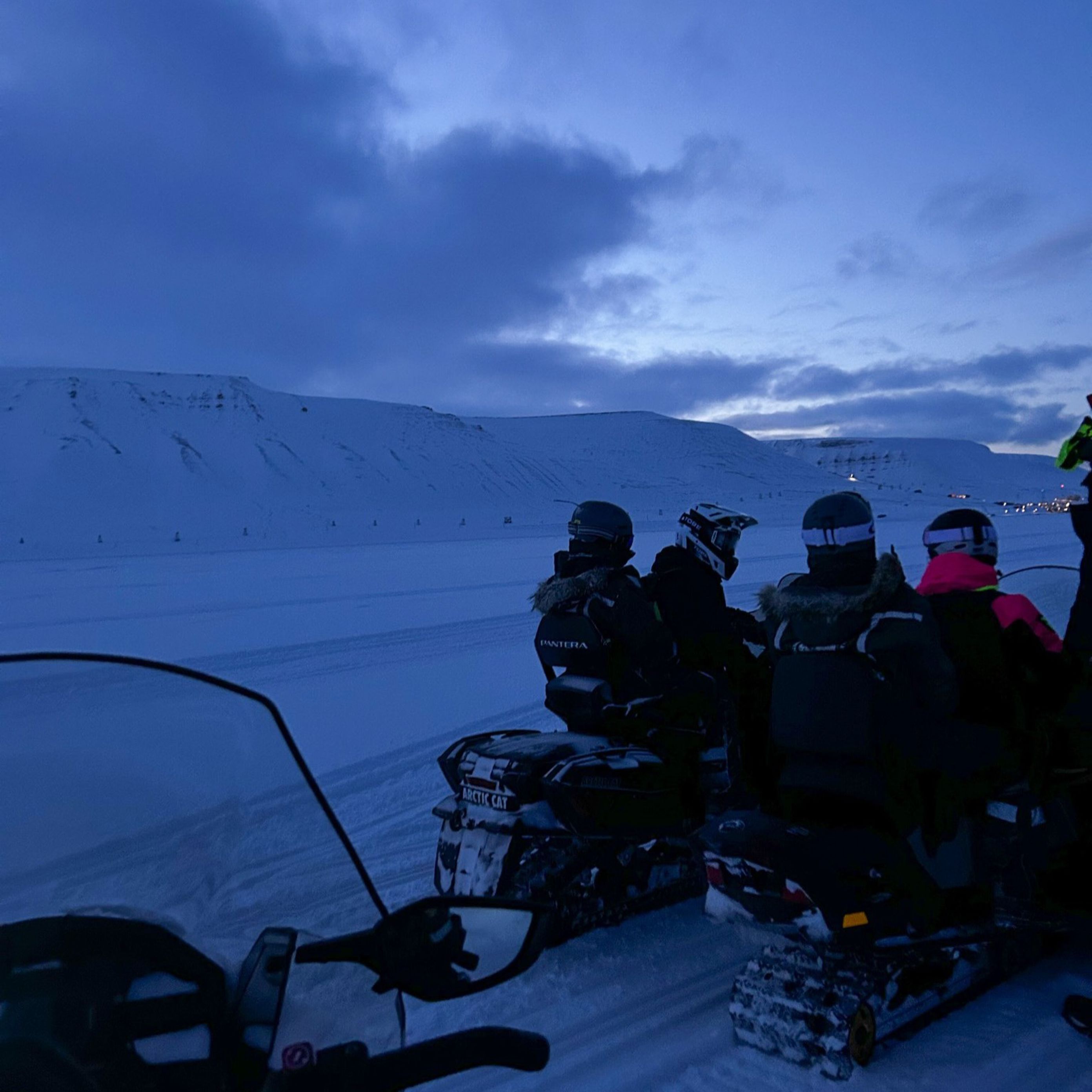 En gruppe snowboardere som sitter på snøen