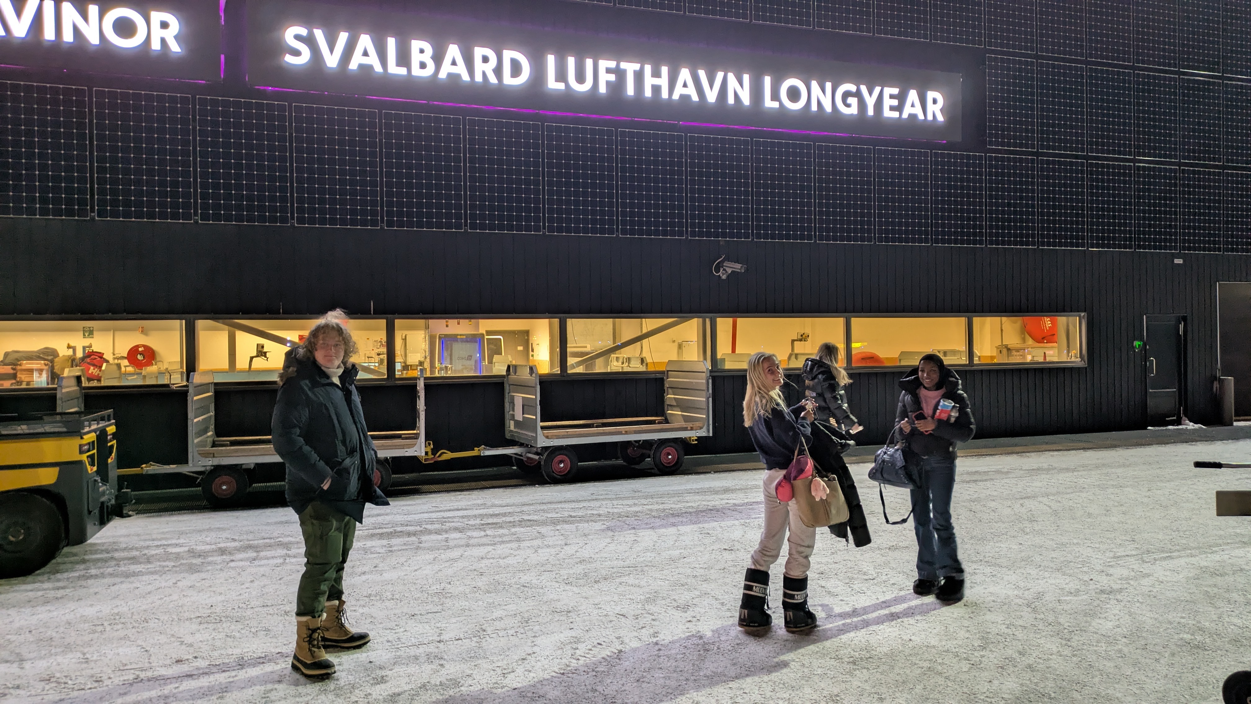 en gruppe mennesker som står foran en bygning med et skilt