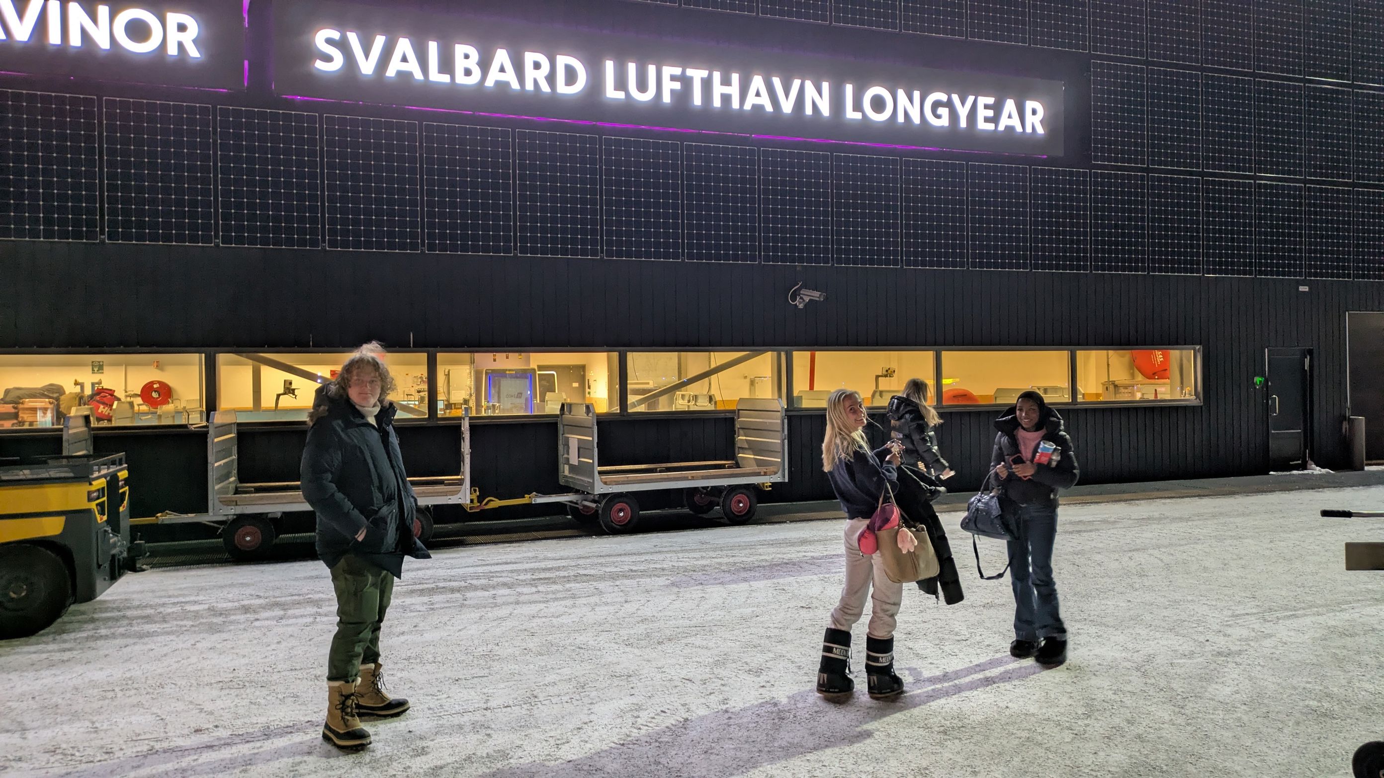 en gruppe mennesker som står foran en bygning med et skilt