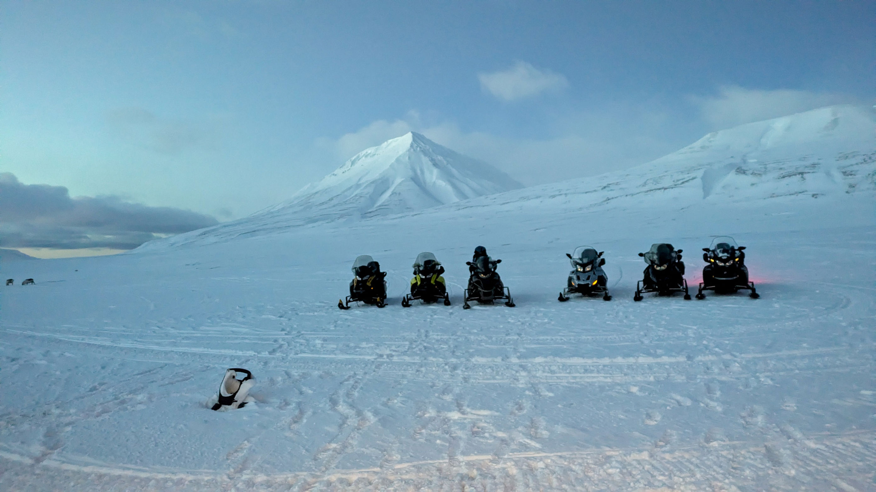 En gruppe snøskutere på et snødekt fjell