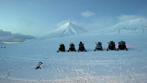 En gruppe snøskutere på et snødekt fjell