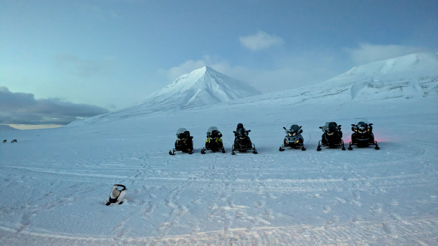 En gruppe snøskutere på et snødekt fjell En gruppe snøskutere på et snødekt fjell
