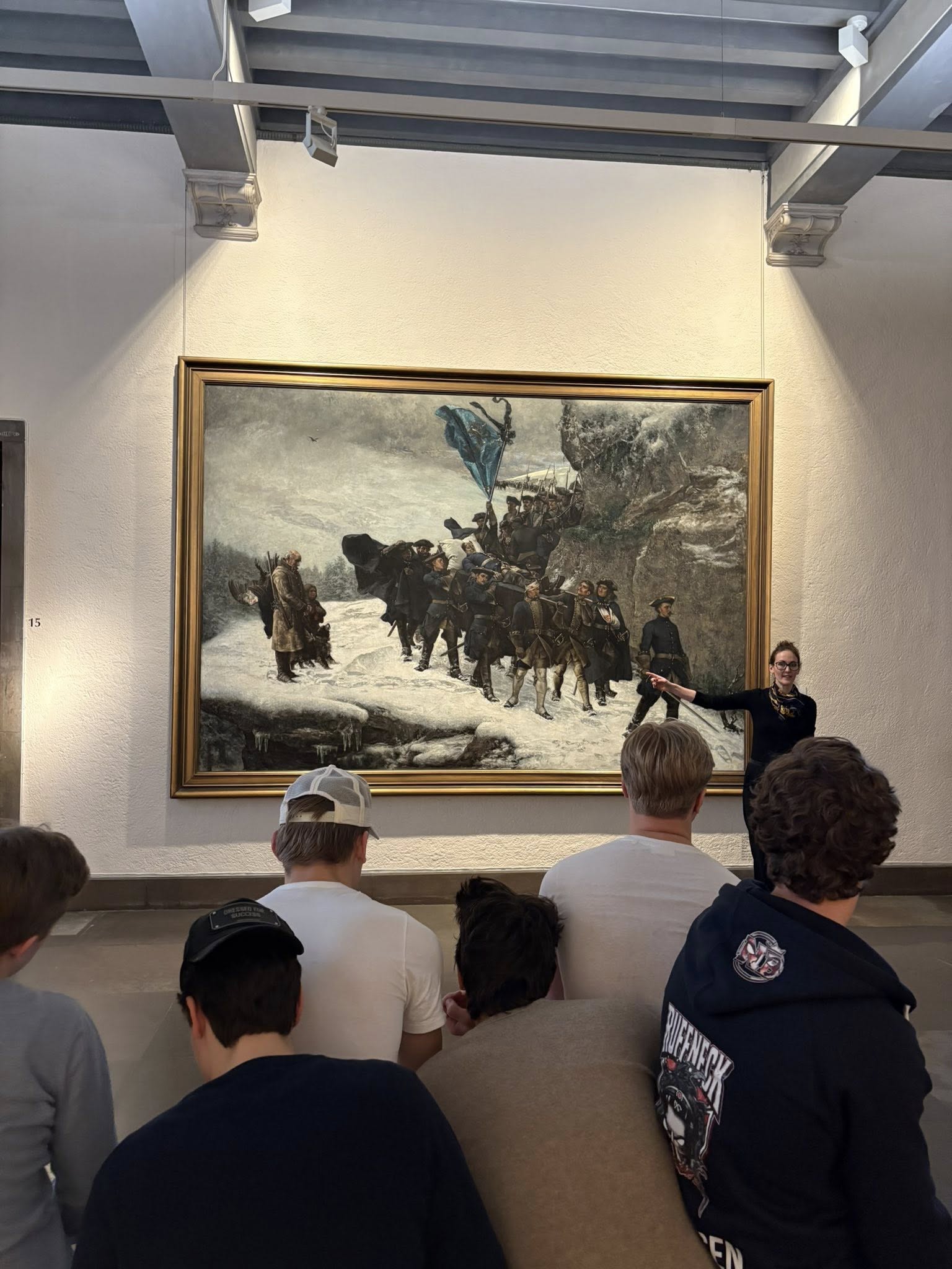 en gruppe mennesker som ser på et maleri på en vegg