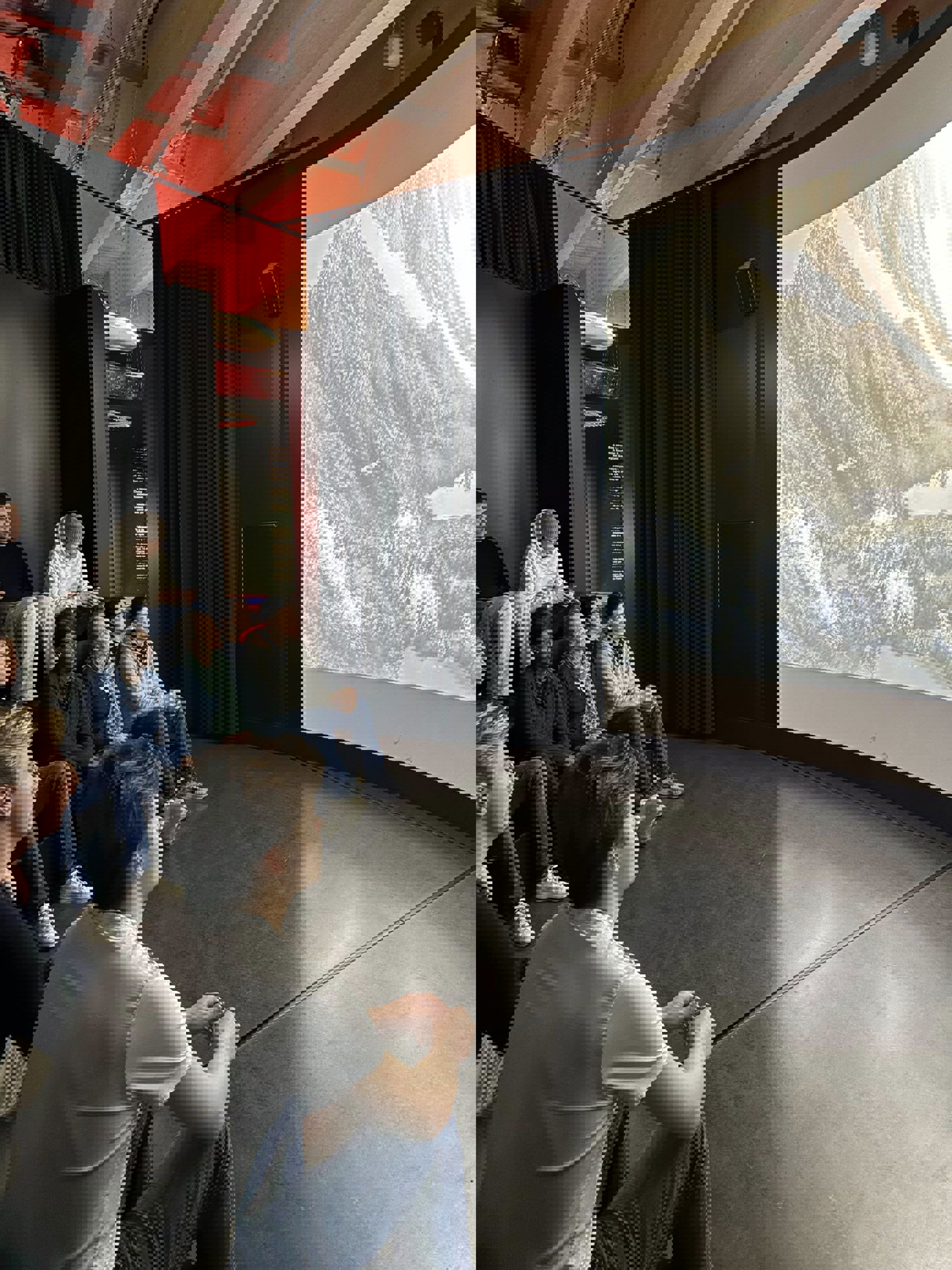 en gruppe mennesker som sitter i et rom med en stor skjerm