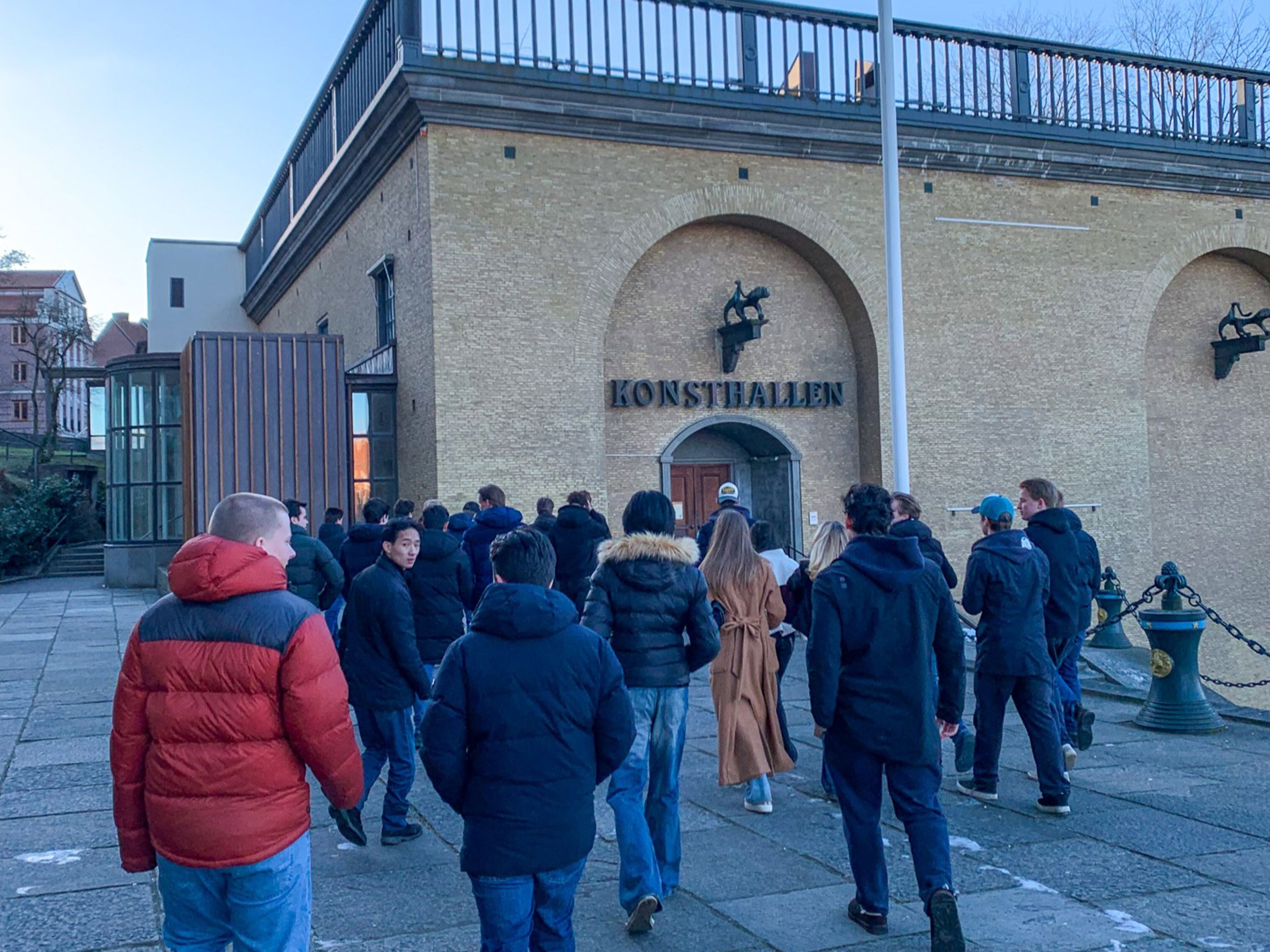 en gruppe mennesker som står utenfor en bygning