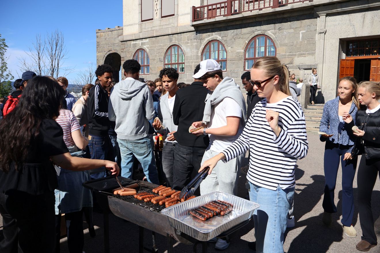 en gruppe mennesker som står rundt en grill med mat på
