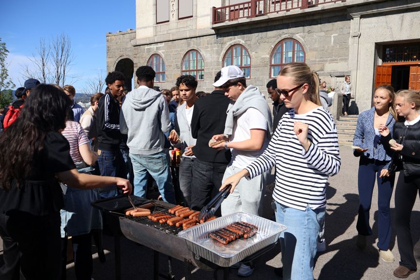 en gruppe mennesker som står rundt en grill med mat på